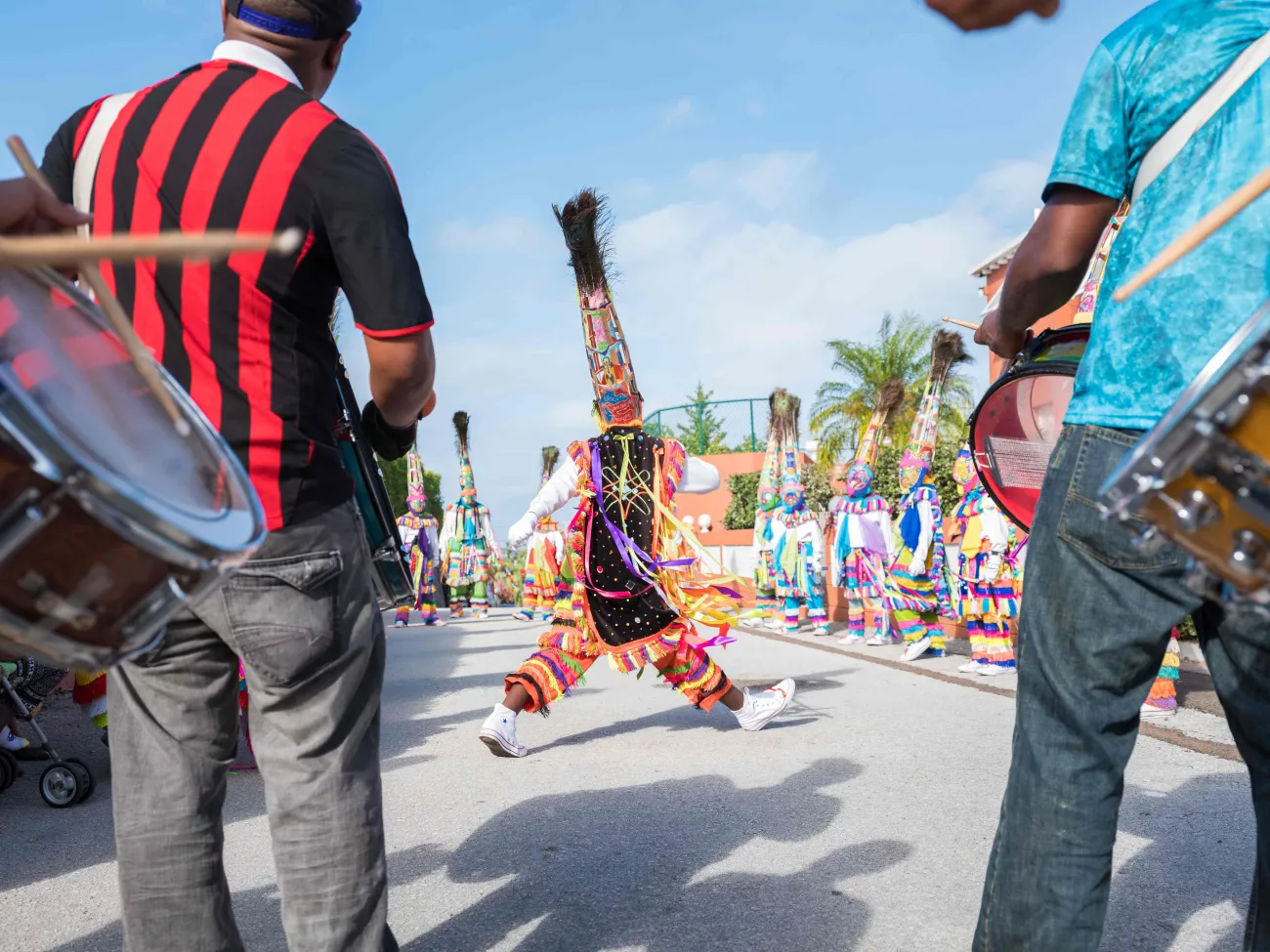 A Gomeby Group is performing in the street with a dancer in the middle.