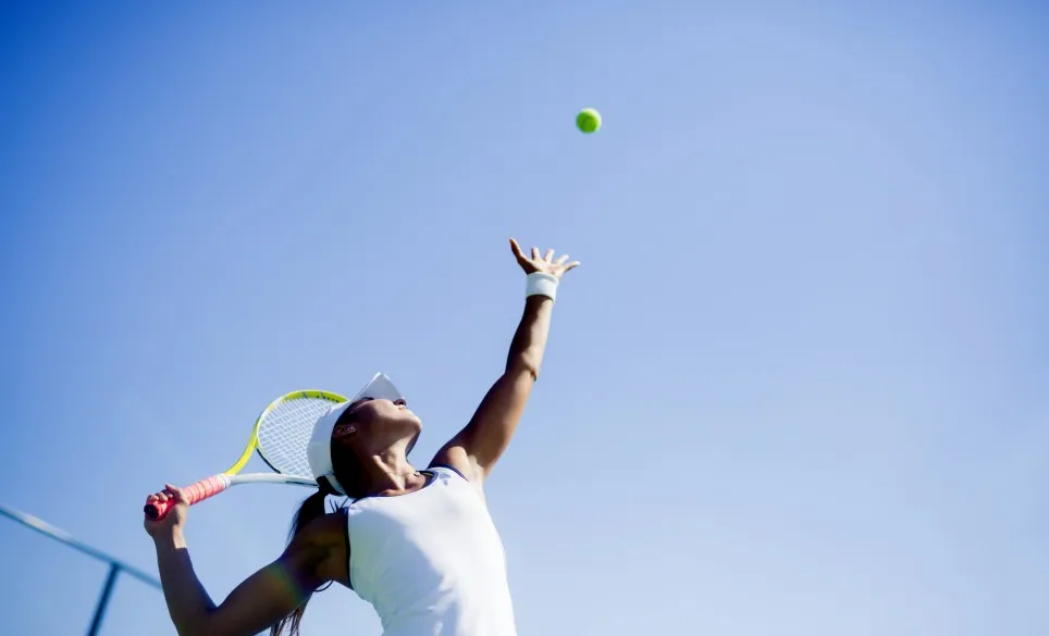 tennis player serving ball