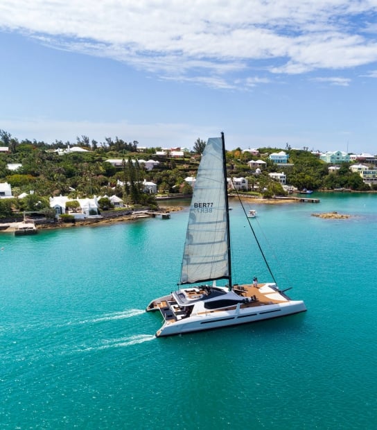 private sail boat gliding along the coastline