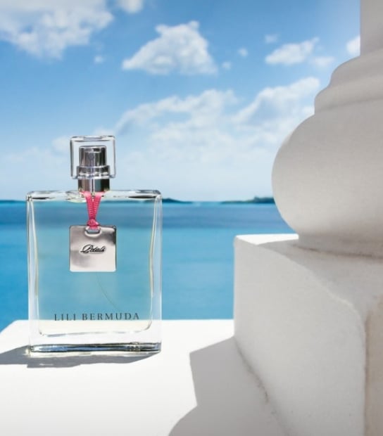 bottle of perfume infront of ocean