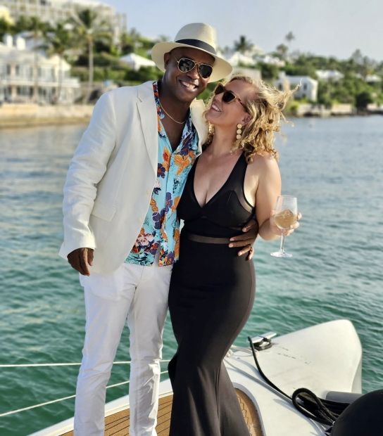 A couple is smiling on boat.