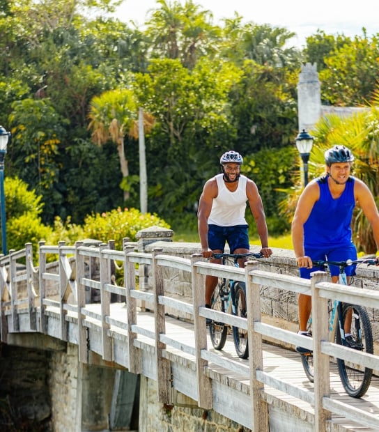 Two men biking by the smallest drawbridge.