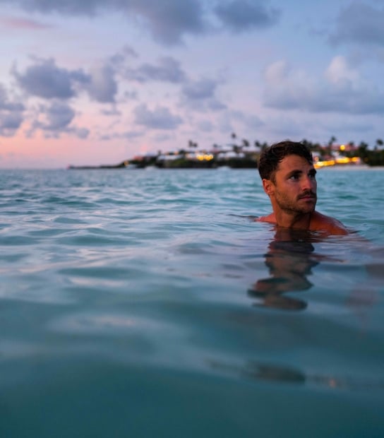 A man is swimming at the beach.