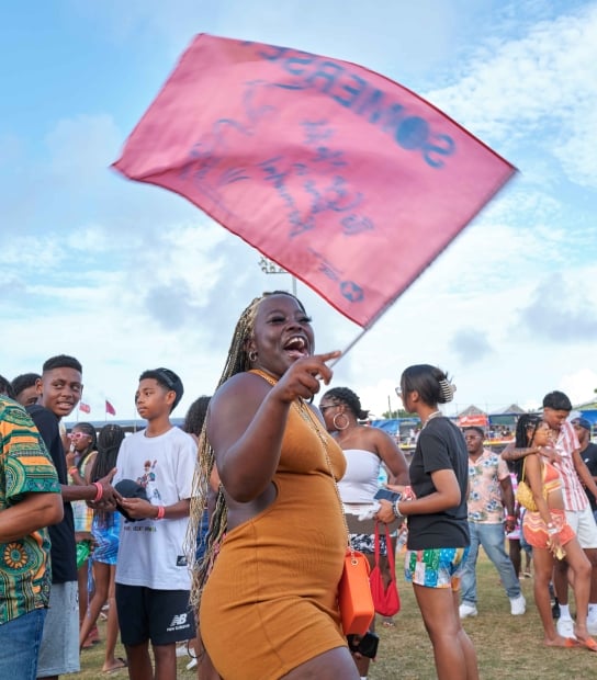 A woman is smiling with a somerset flag.