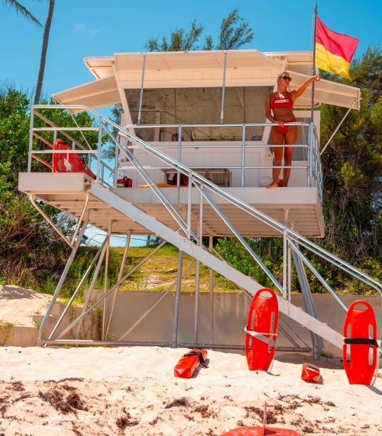 A life guard is pointing to the sea.
