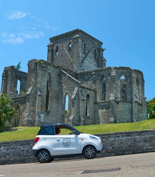 A microcar is driving passed the unfinished church