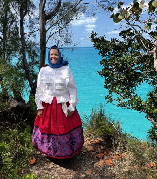 A woman is posing in traditional portuguese regalia.