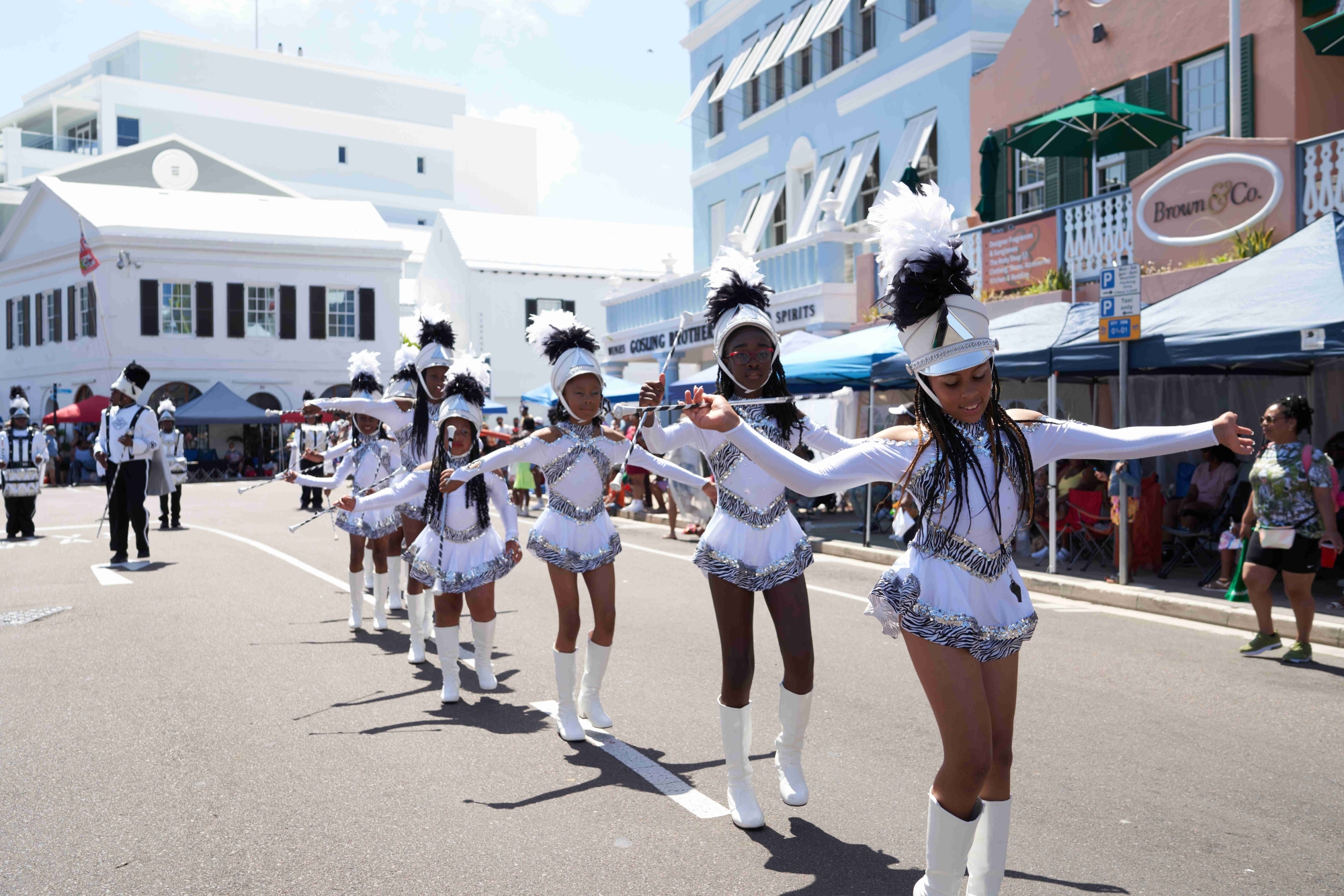 A group of young girls are dancing in majorettes. 