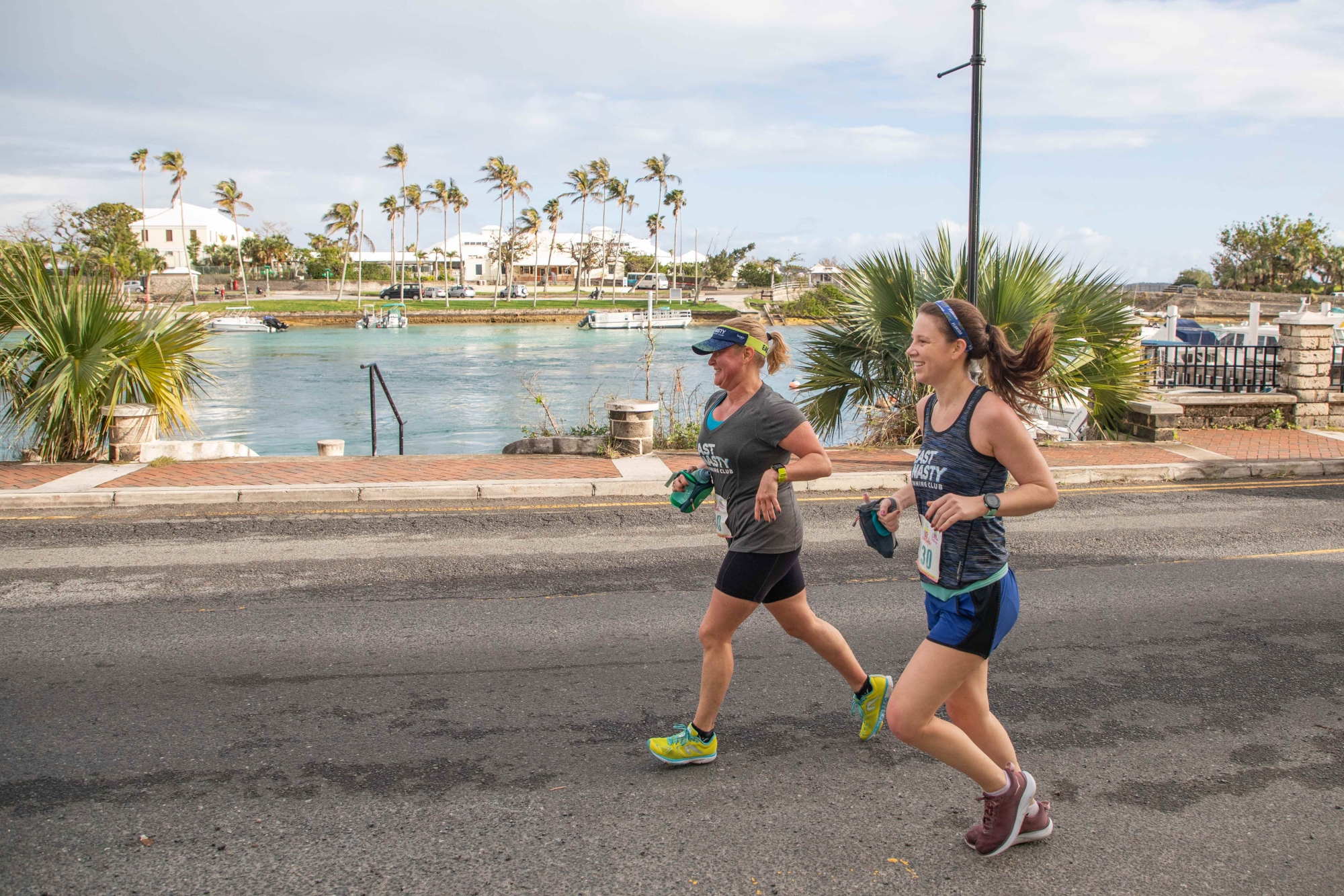 Two women are running on a Bermuda road. 