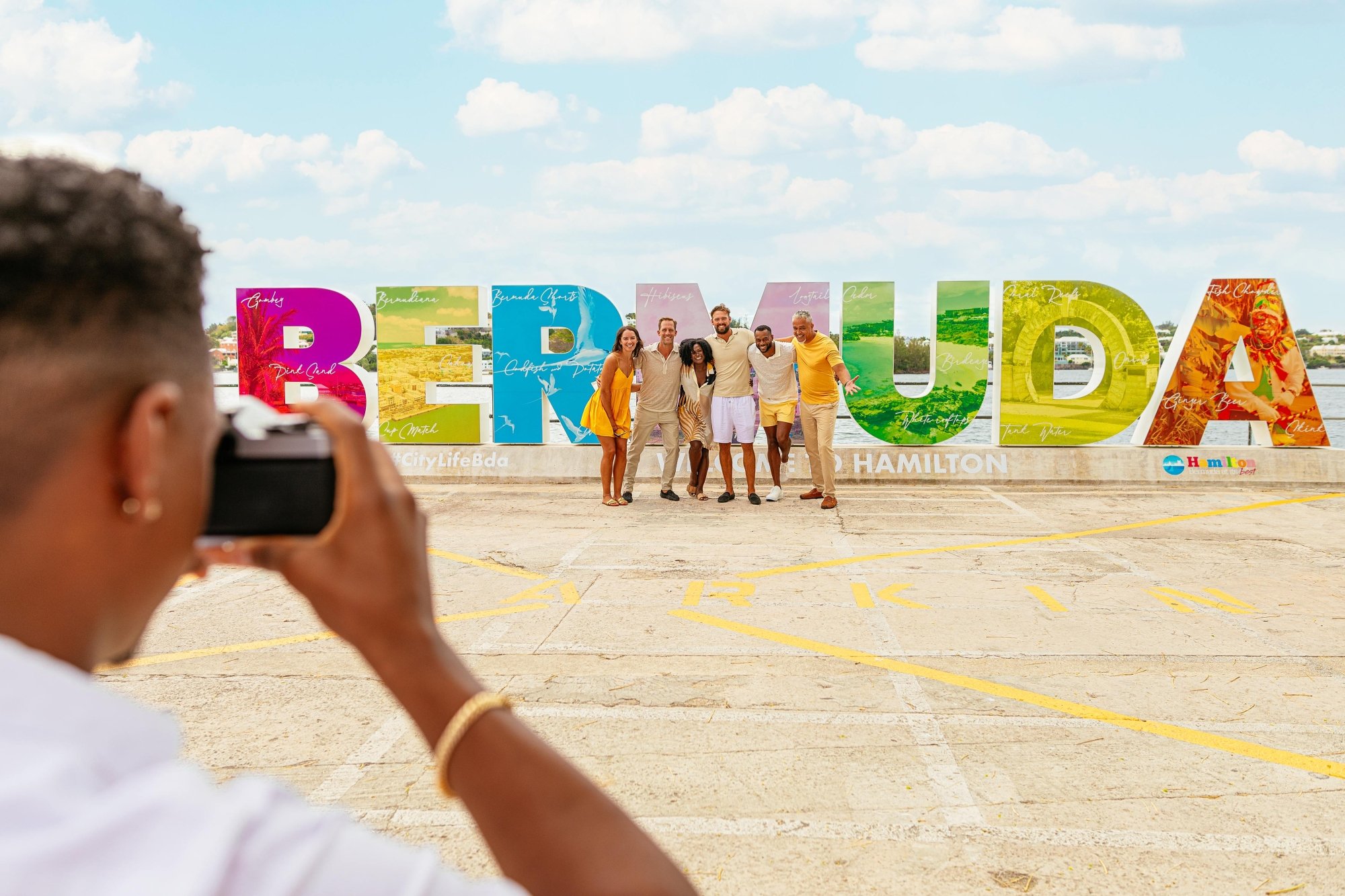 People posing by the Bermuda sign.