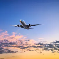 An airplane flying at sunset
