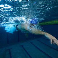 A swimmer swimming under water at an indoor pool in Bermuda
