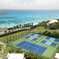 An aerial view of tennis and pickleball courts next to the ocean in Bermuda