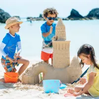 A group of kids are playing in the sand at the Hamilton Princess Beach Club